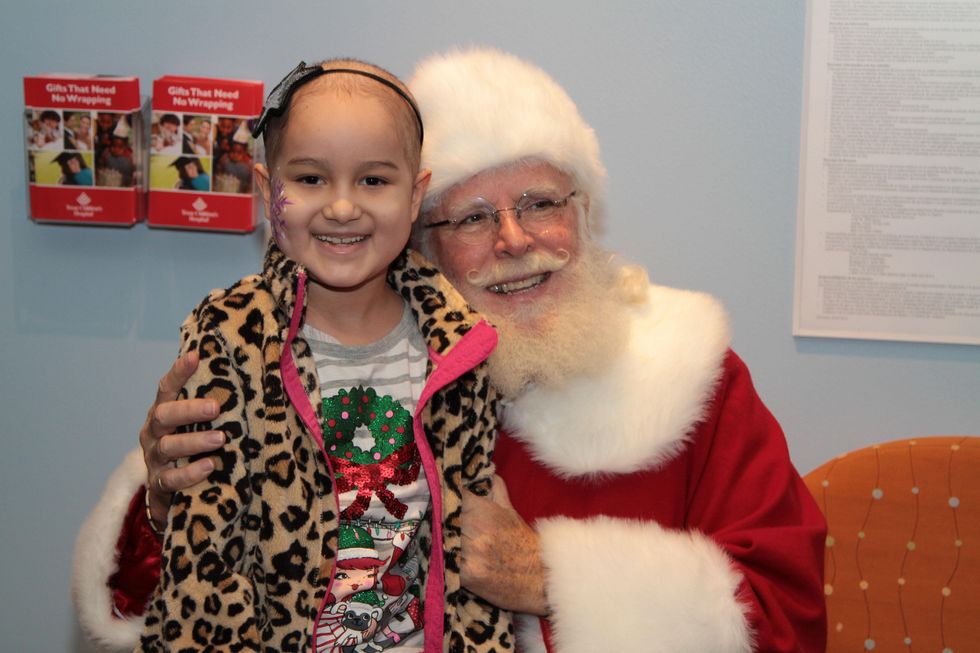112 A patient poses with Santa at Santa visits Texas Children's Cancer Center December 2014