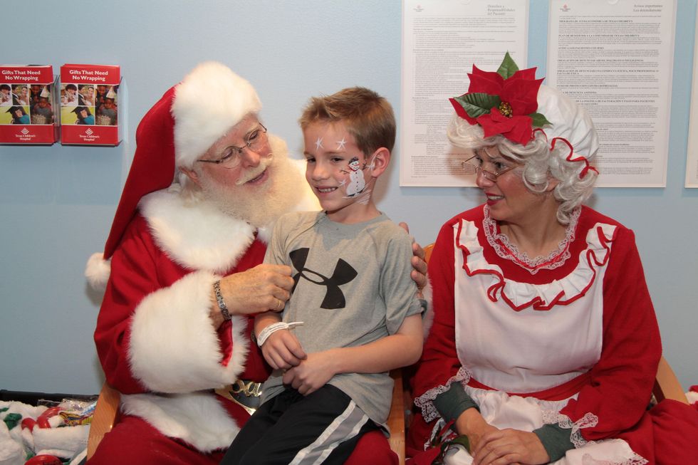 167 A patient talks with Santa and Mrs. Claus at Santa visits Texas Children's Cancer Center December 2014