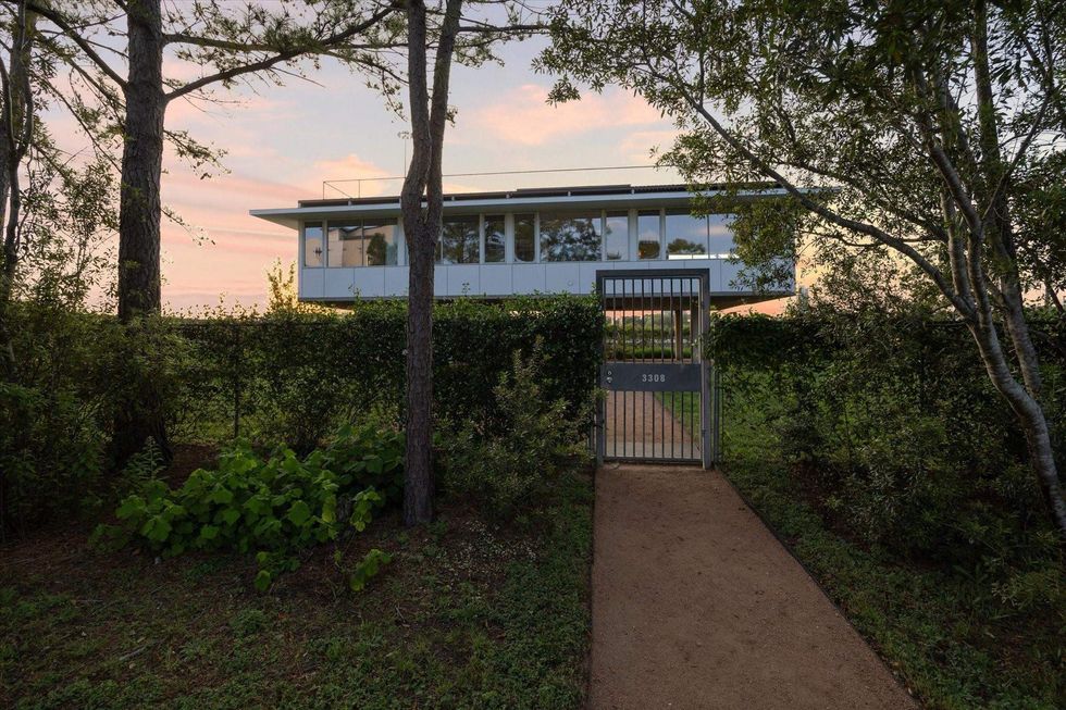 3308 St. Emanuel St. behind a gate bordered by trees