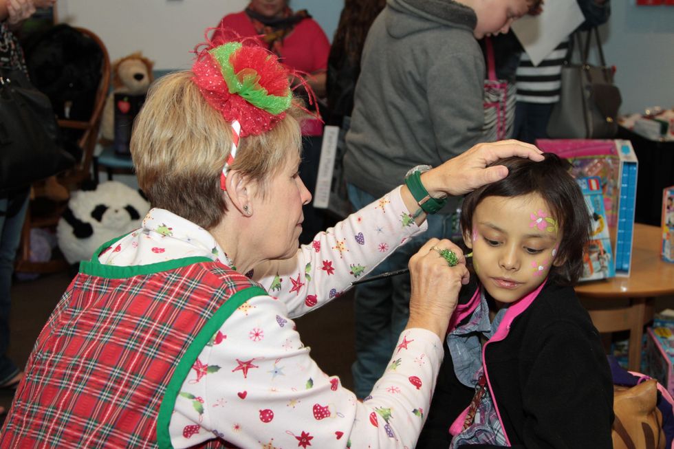 54 A patient gets her face painted at the holiday party at Santa visits Texas Children's Cancer Center December 2014