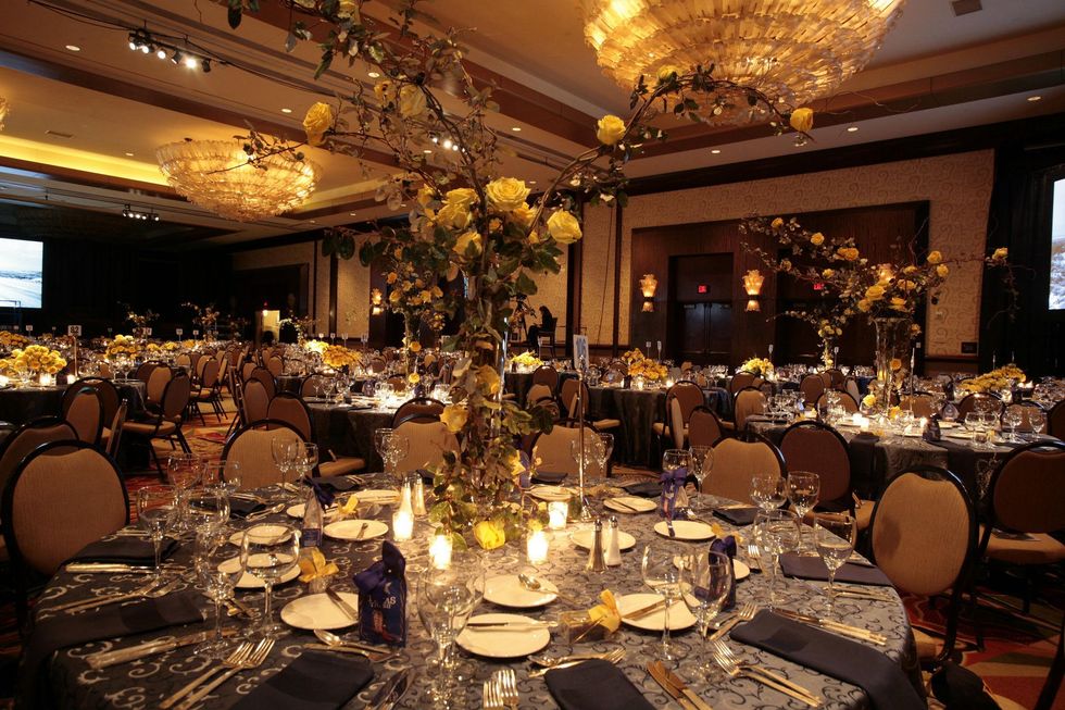 54 Yellow rose centerpieces at the venue at An Evening with a Legend February 2015