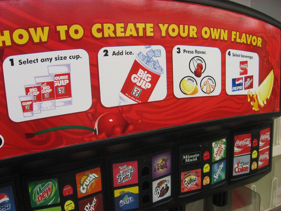 Big Gulp giant soda cups are arranged in size order in a store on