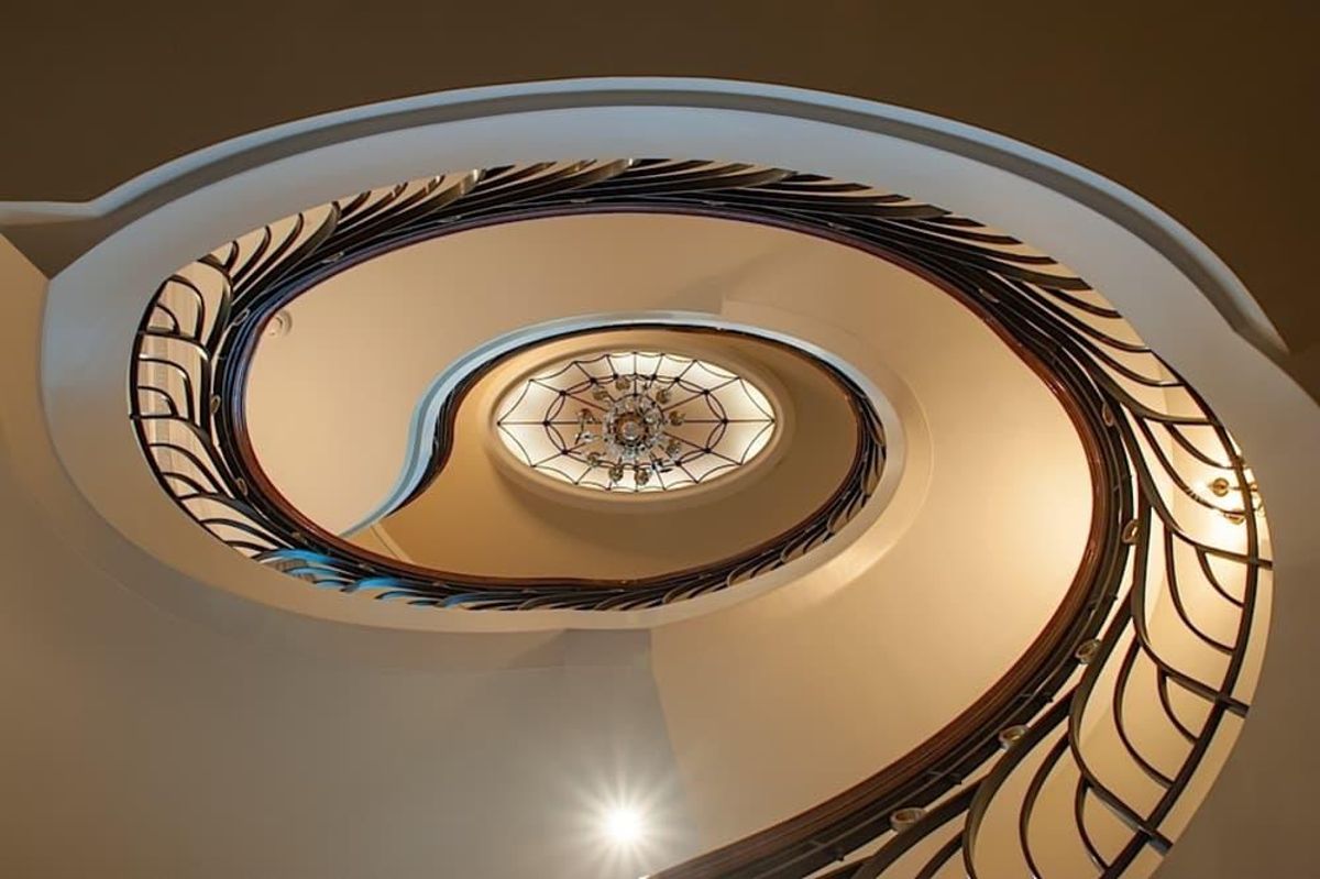 The circular staircase features a railing and balustrade designed by ...