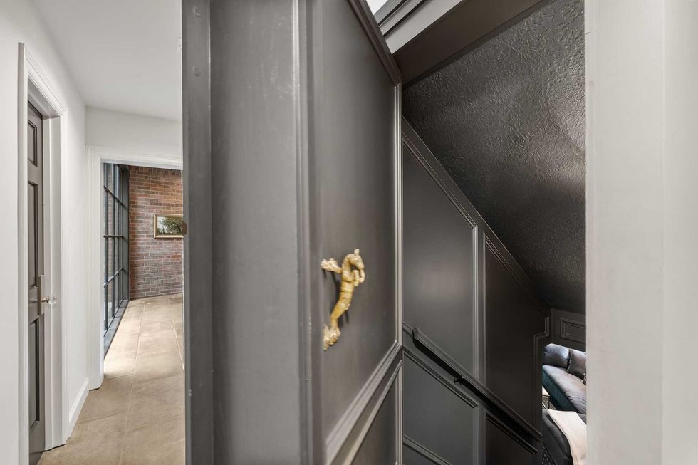 A door opening to a staircase leading down to the movie room