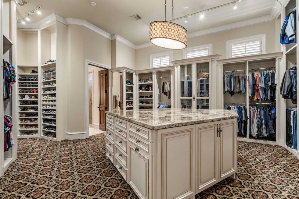 A massive owner's suite dressing room of 50 Patti Lynn Lane with shelving for shoes, an island of drawers and plenty of space for clothes