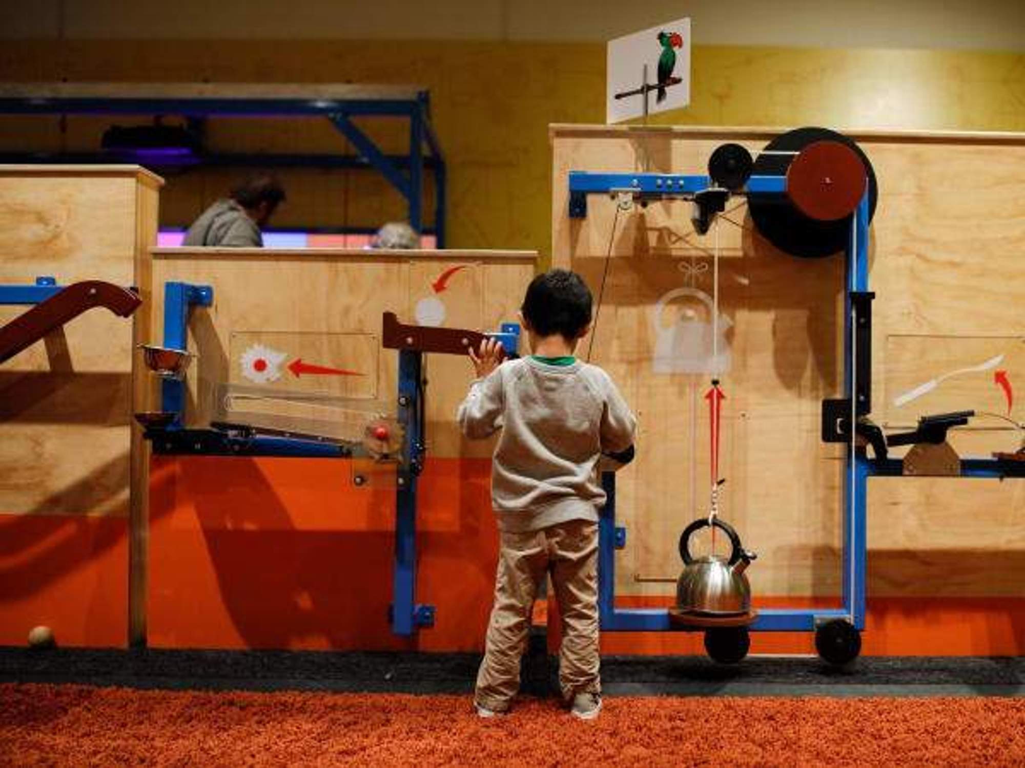 A small child constructs a Rube Goldberg machine at the Children's Museum Houston.