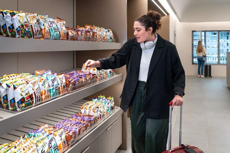 A traveler looks at the chips and cookies selection in United Club Fly