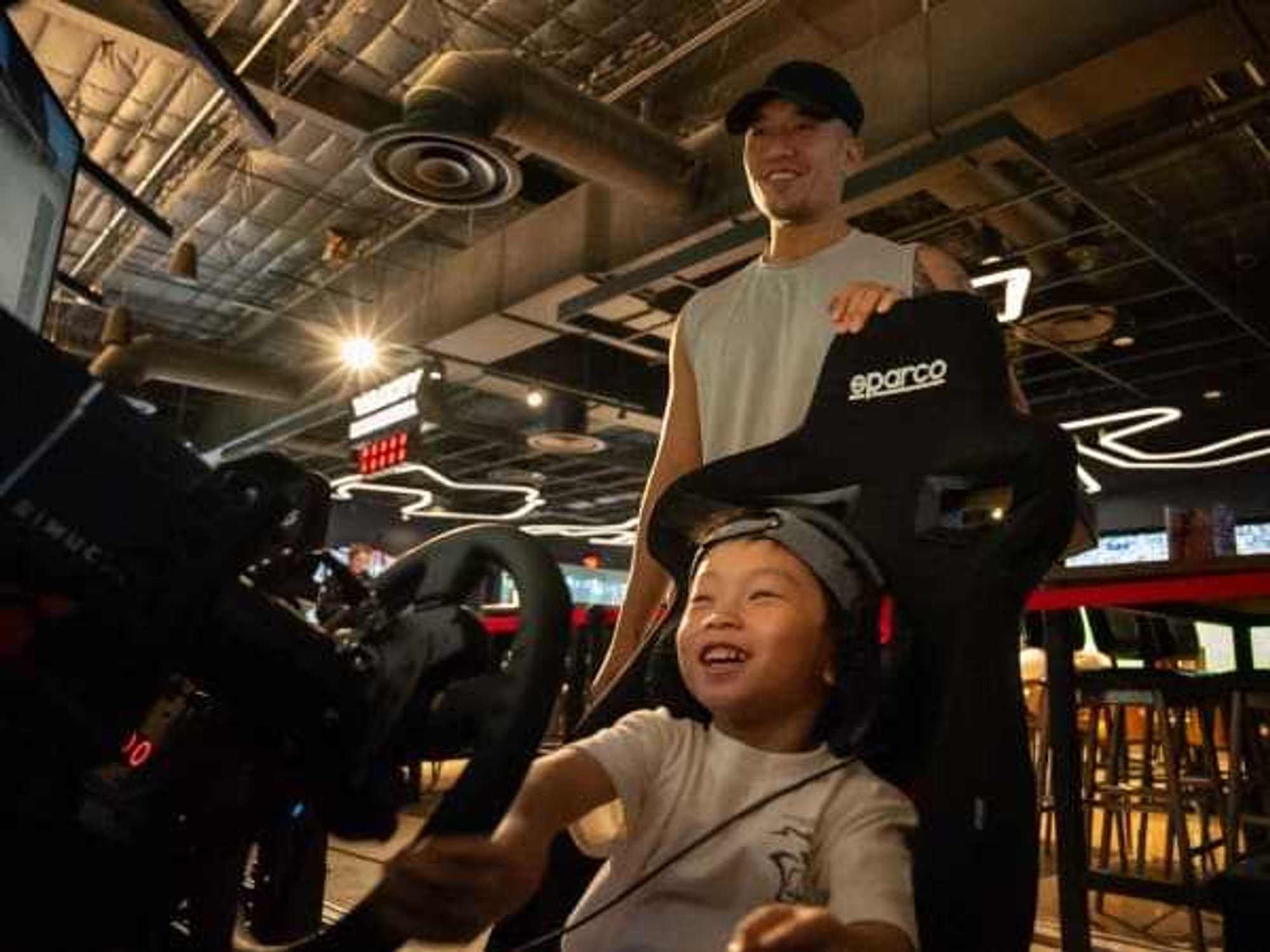 A young boy plays simulated racing at Velocity in Houston