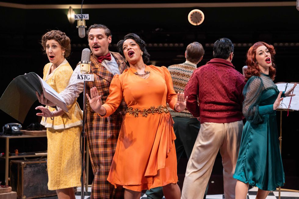 Actors in 1940s costumes around a microphone