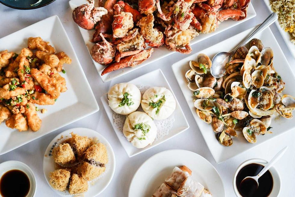 An array of dumplings and seafood on small plates.