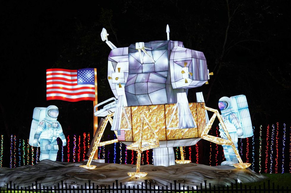 An illuminated lunar module with astronauts and an American flag, part of Galaxy Lights