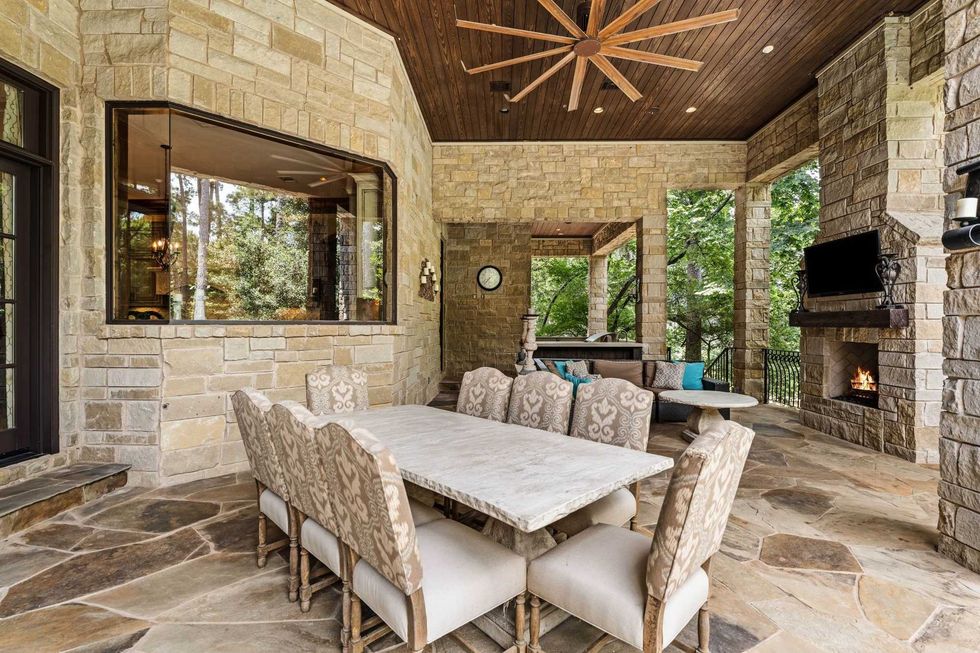 Another view of the patio of 50 Patti Lynn Lane, showing the dining table and outdoor fireplace