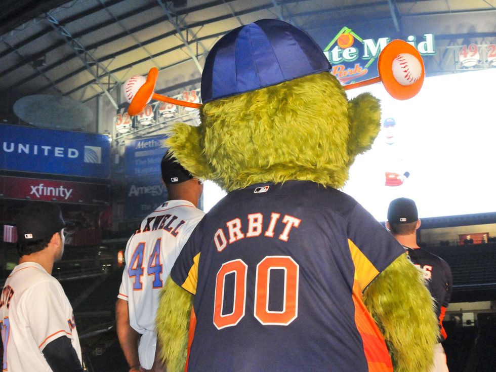 Astros Mascot,Orbit holding a flag while standing on - Depop