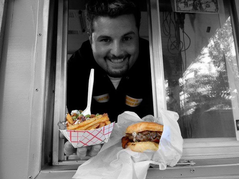 Bernie of Bernie's Burger Bus holding fries and hambuger