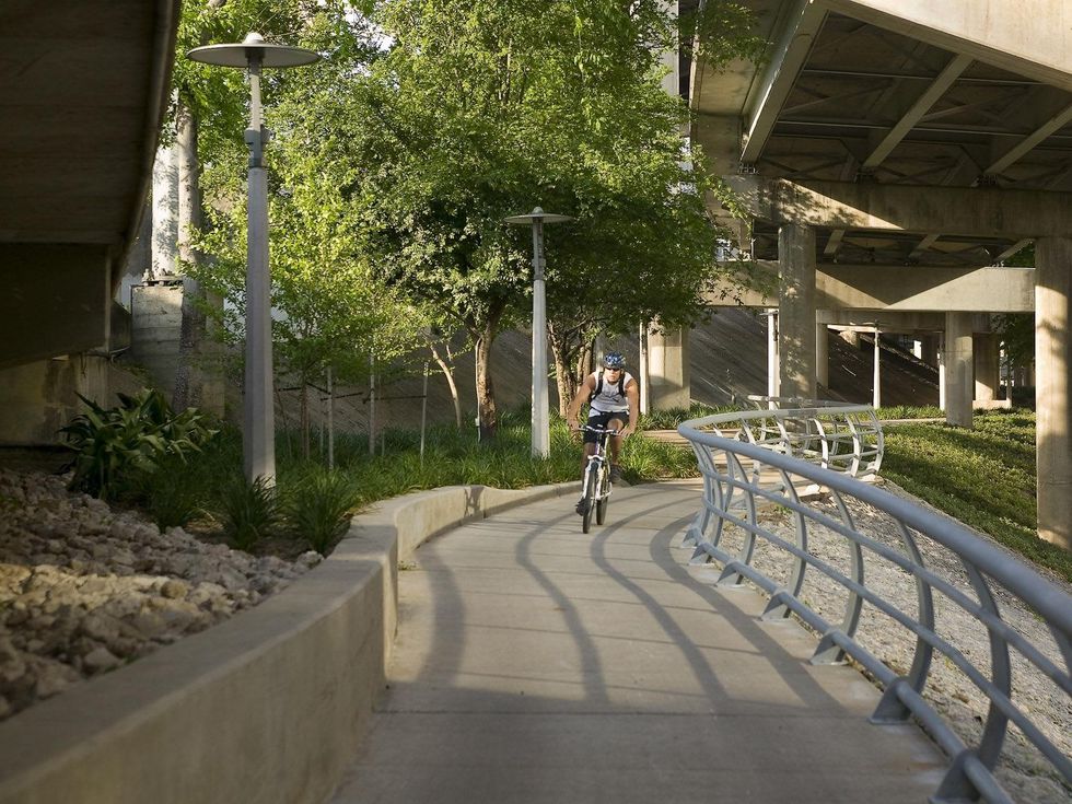 Buffalo Bayou Park cyclists bicycle on bridge near downtown Houston