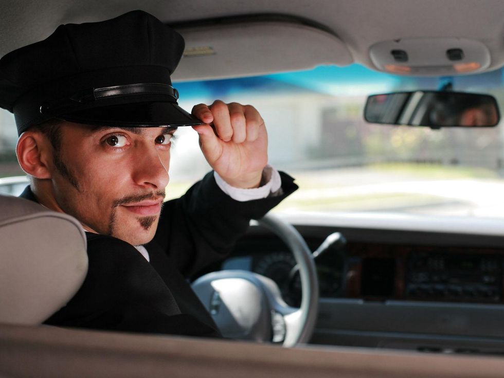 car driver tipping his hat from front seat chauffeur