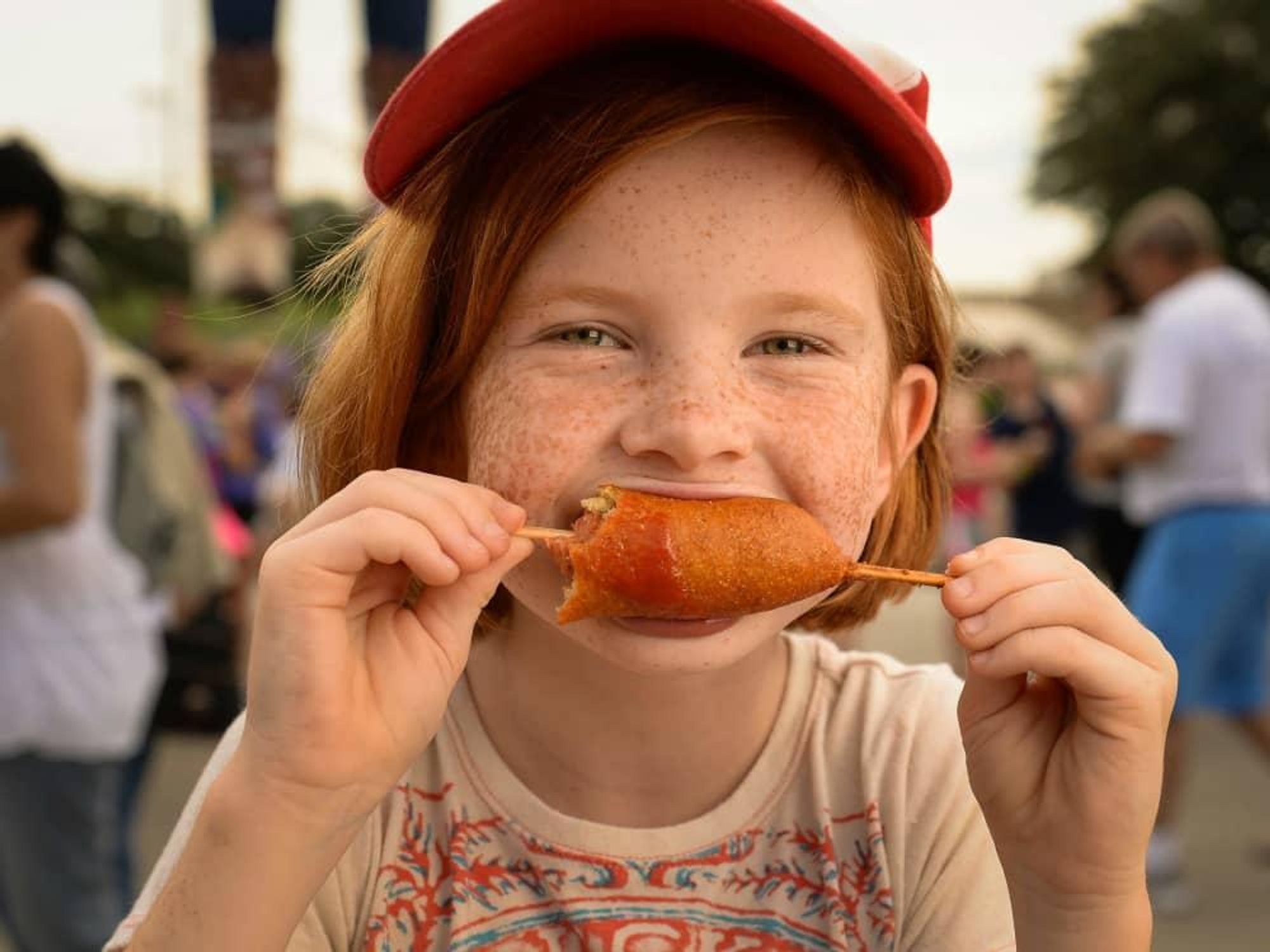 Child eating a corn dog at the State Fair of Texas