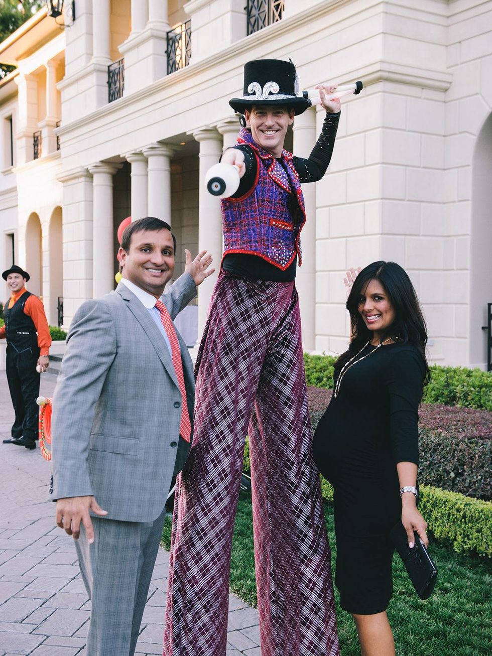 Cody and Kusum Patel with Stilt Walker at The Memorial Hermann at the Under the Boardwalk kickoff party
