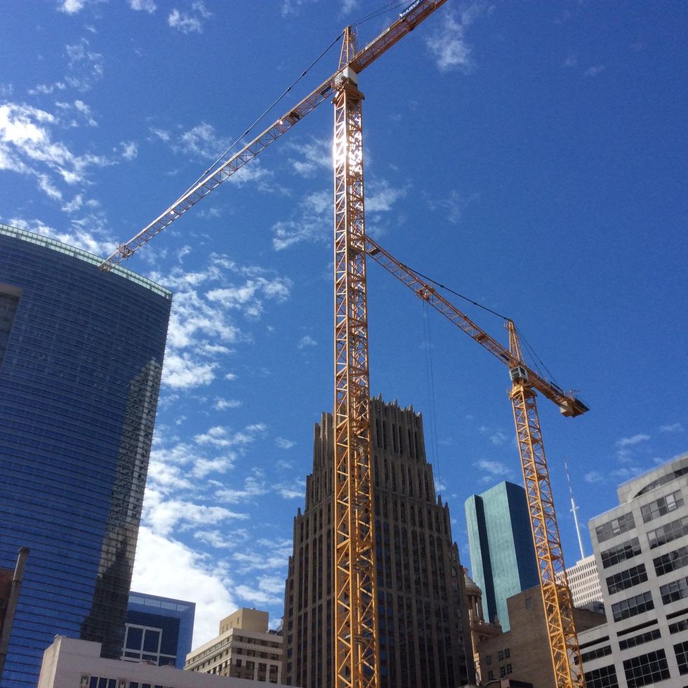 Construction cranes work under a blue October sky over Main Street in downtown Houston October 2014
