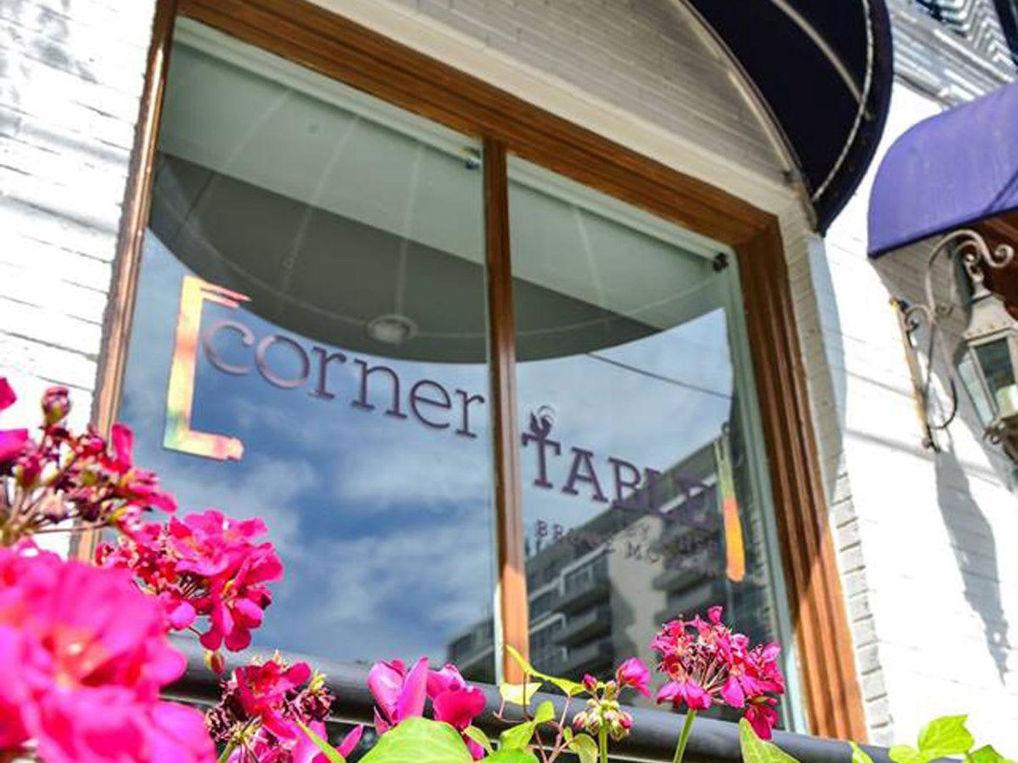 Corner Table exterior with sign and flowers