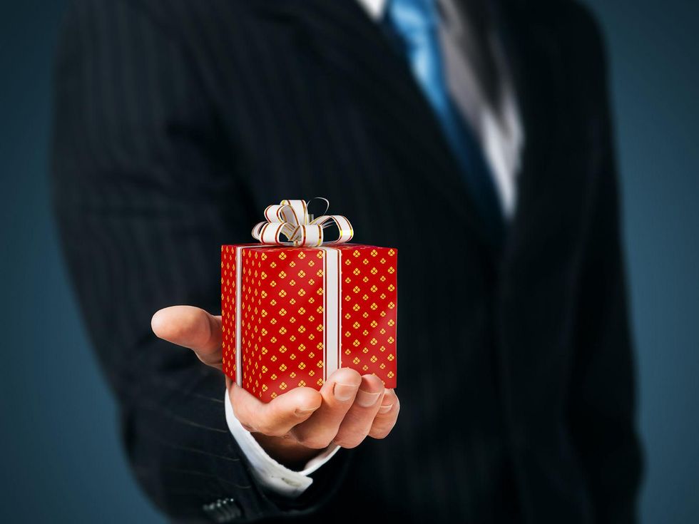 corporate gift giving man in suit holding small present