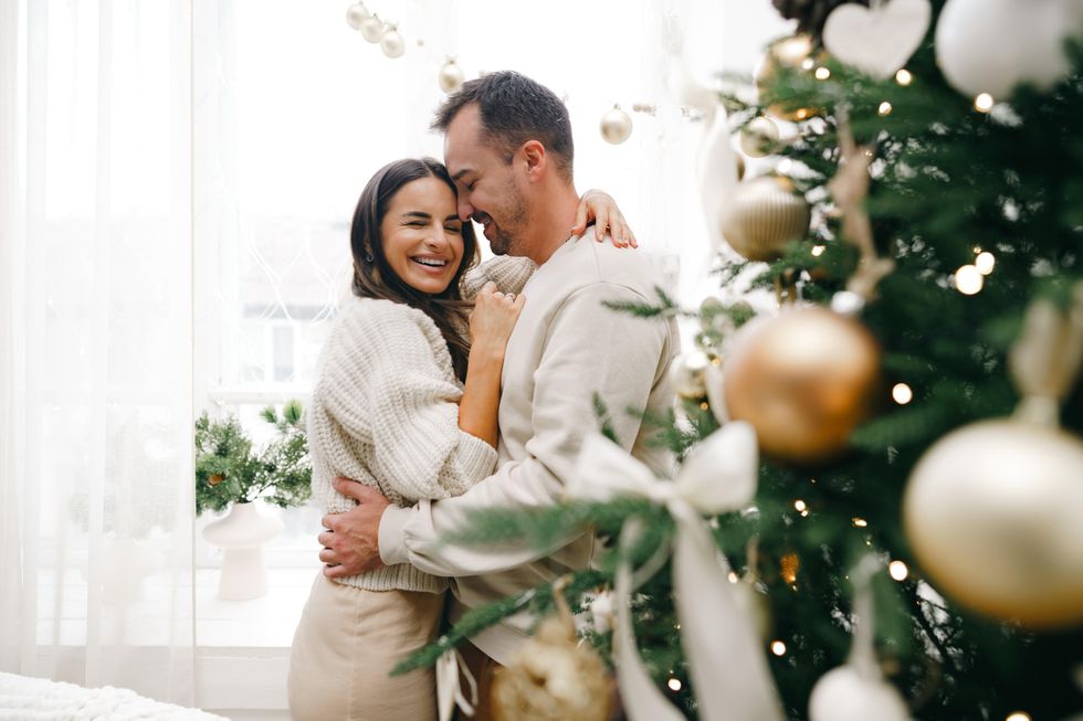 Couple hugging in front of Christmas tree