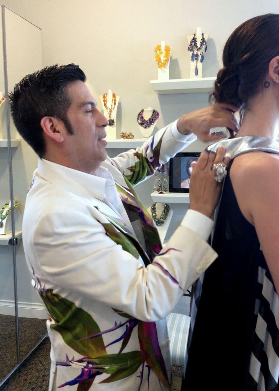 Daniel Esquivel pins and tucks a garment under construction during a fitting.