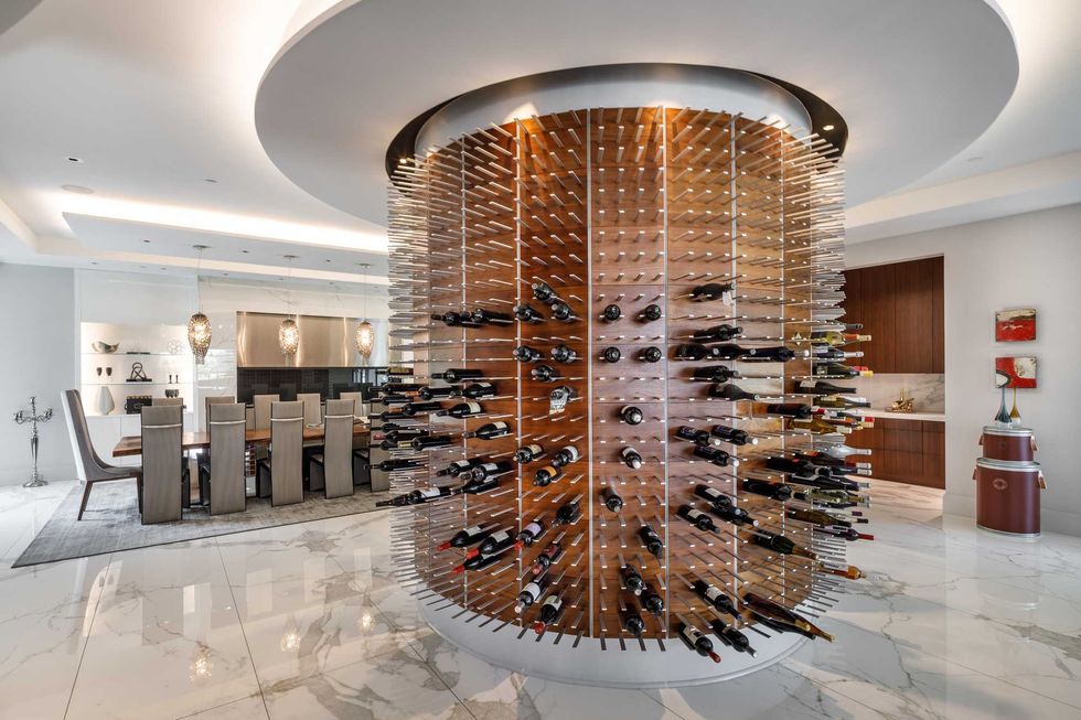 Dining room of 3102 Noble Lakes Lane with a huge cylindrical wine bottle holder and display
