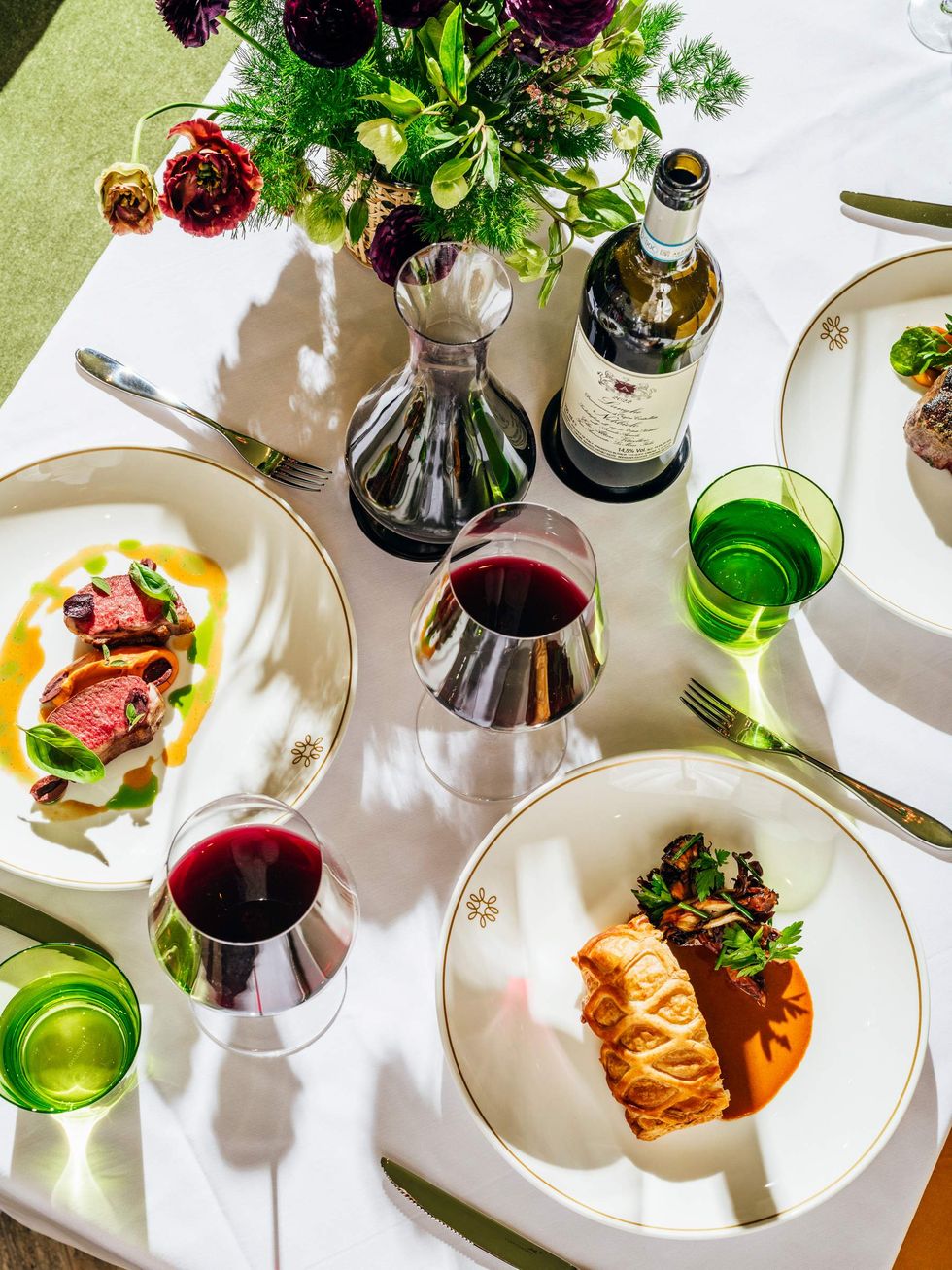 Duck Wellington on a table with wine