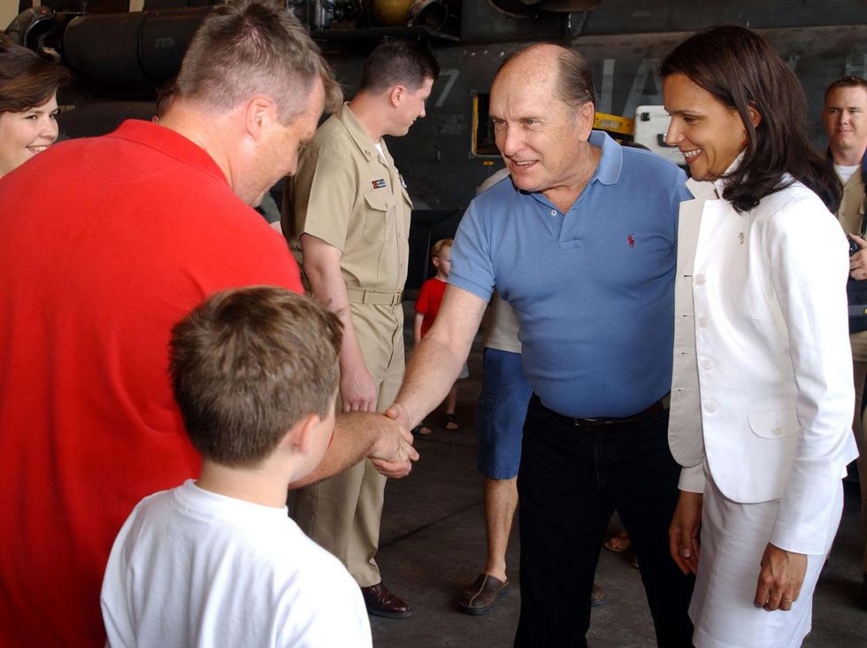 Duvall with future wife Luciana Pedraza (right) shaking hands with a member of the "The Black Stallions" of Helicopter Combat Support Squadron Four at the Taormina Film Fest in Sicily in June 2003