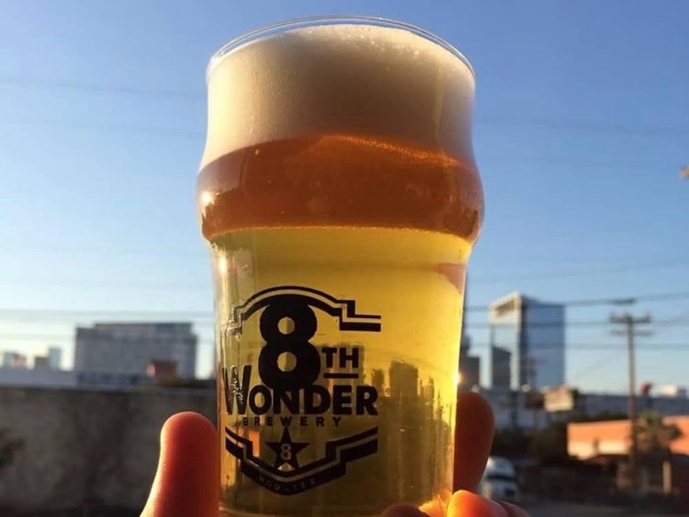 Eighth 8th Wonder Brewery glass of beer with skyline in background