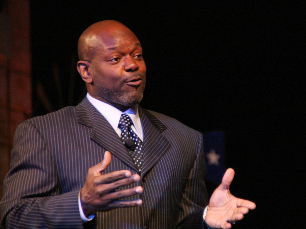Emmitt Smith, in suit, speaking