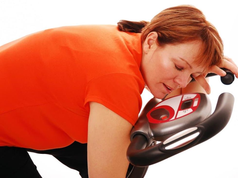 Exercise, fitness, woman asleep on the bike