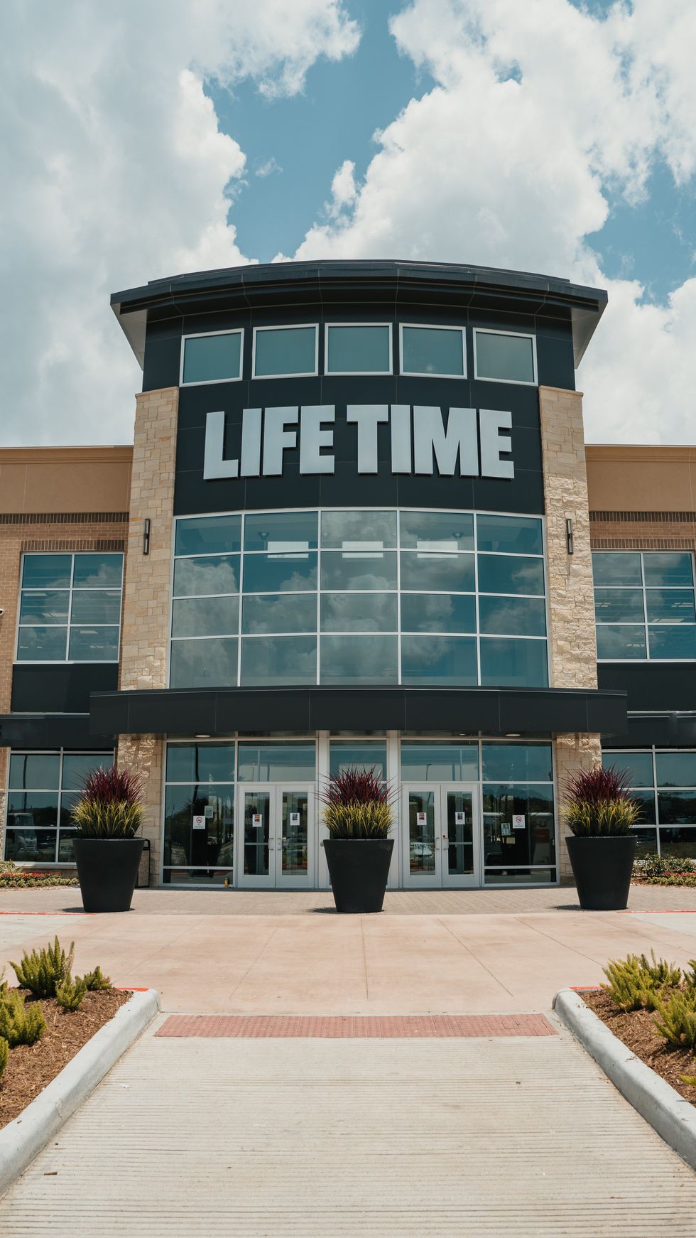 Exterior of Life Time Fitness Sienna with the Life Time logo on the top of the building