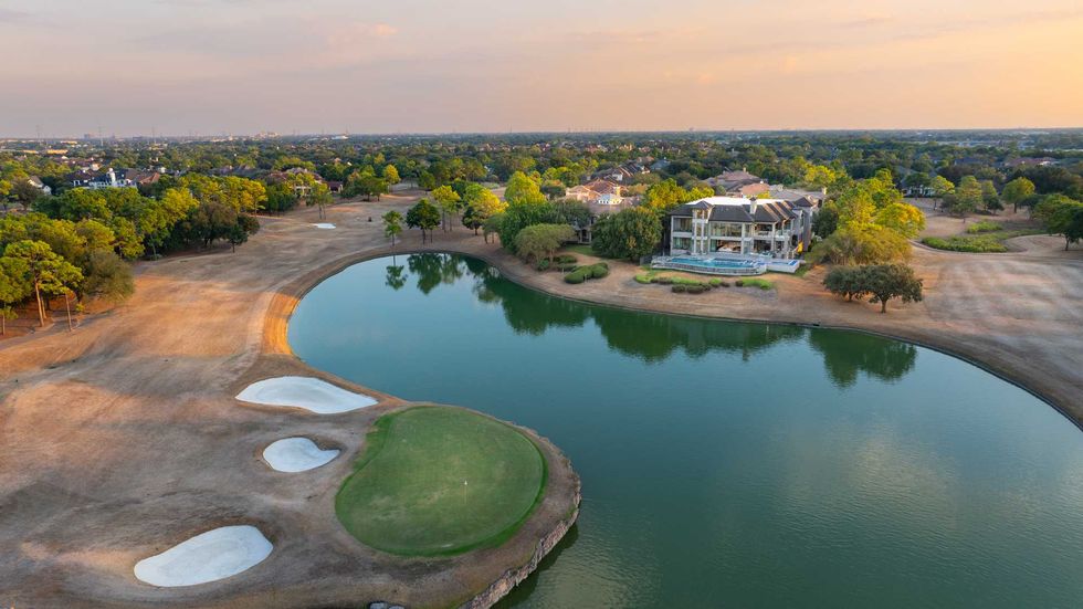 Exterior of the back of 3102 Noble Lakes Lakes Lane showing it sitting right on a lake by a golf course