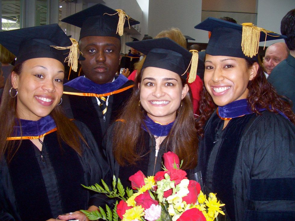Fayza as graduate with flowers and friends