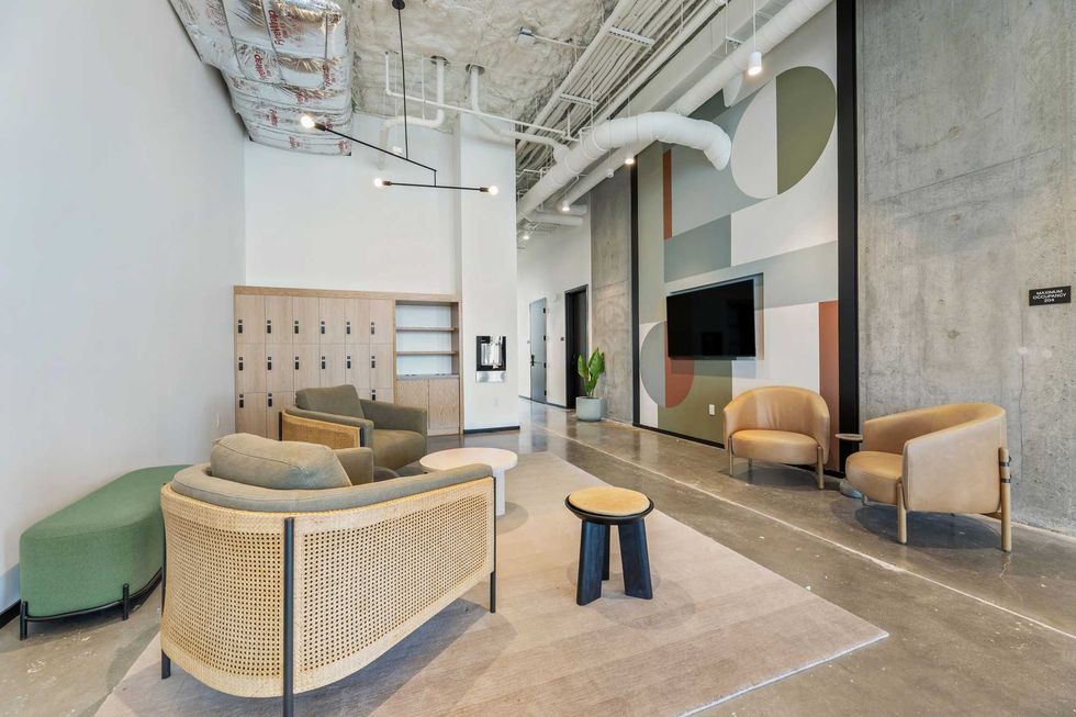 Forme apartment building gym lounge with lockers, art on the wall, and comfy chairs