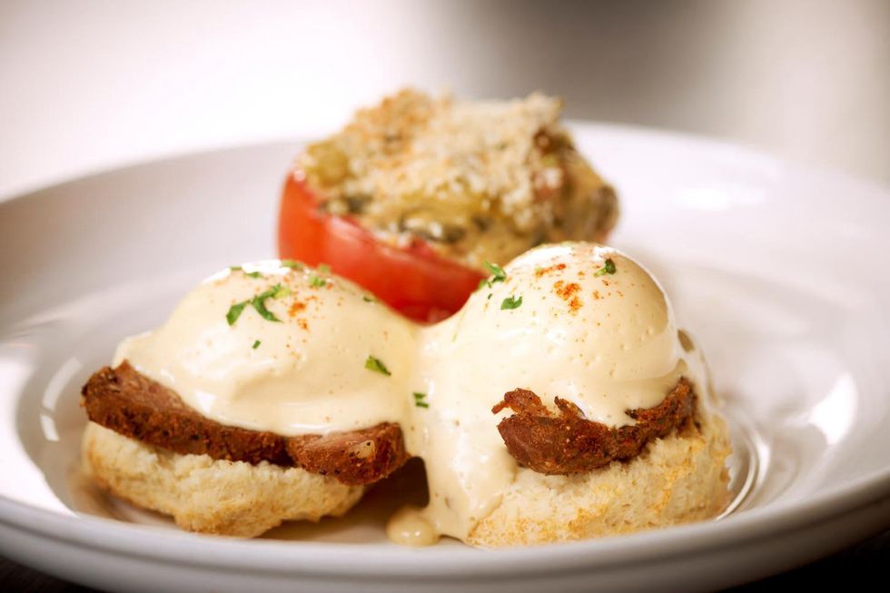 Haven Houston Egg Boudreaux poached eggs, buttermilk biscuits, tasso ham, Hollandaise and mustard greens-stuffed tomato