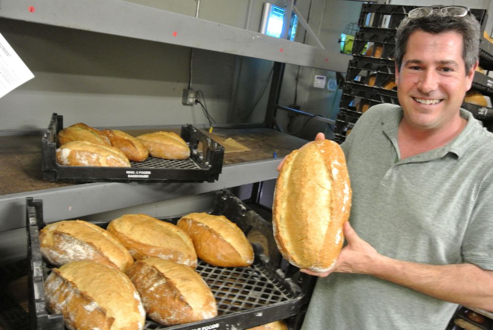 Heath Wendell., owner of Slow Dough Bread Co., holding a slow-dough Pugliese loaf