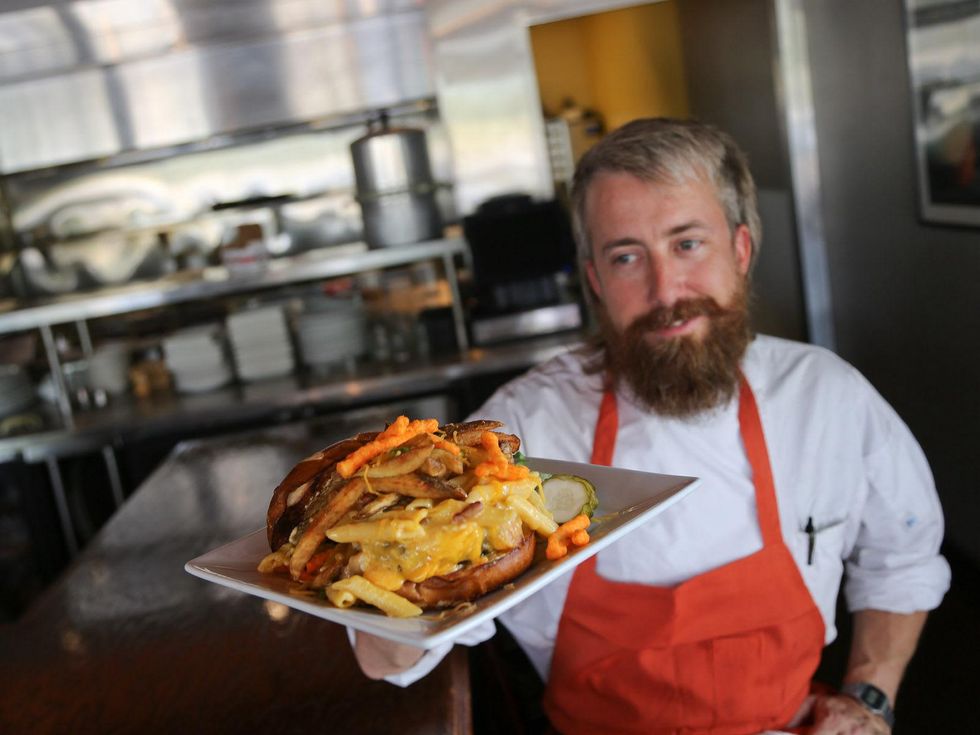 Hollister restaurant Houston July 2013 chef cook holding hamburger with Cheetos