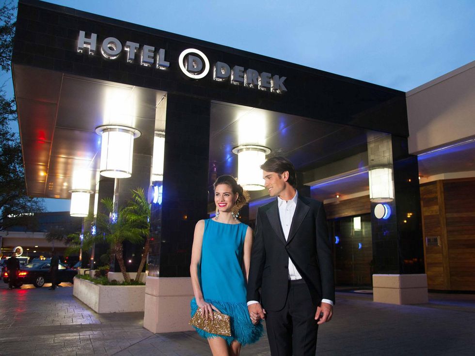 Hotel Derek couple walking outside hotel at night