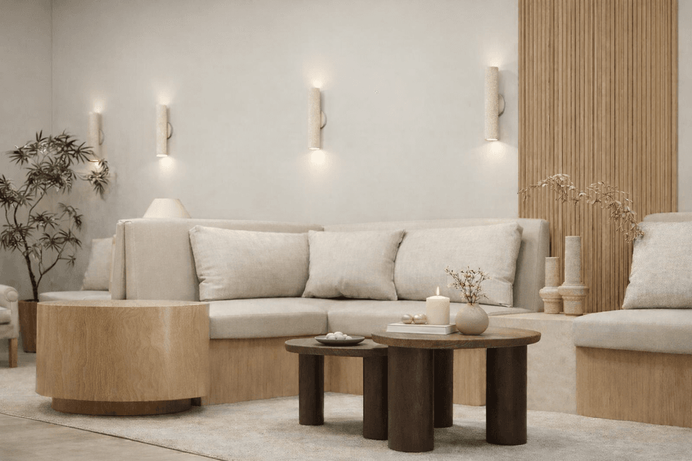 Image of a curved sofa with two round tables in front of it with candles on them