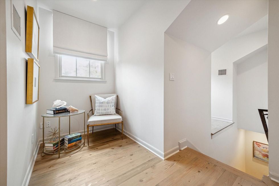 Image sof a wide chair and side table tucked into an alcove at the top of a staircase