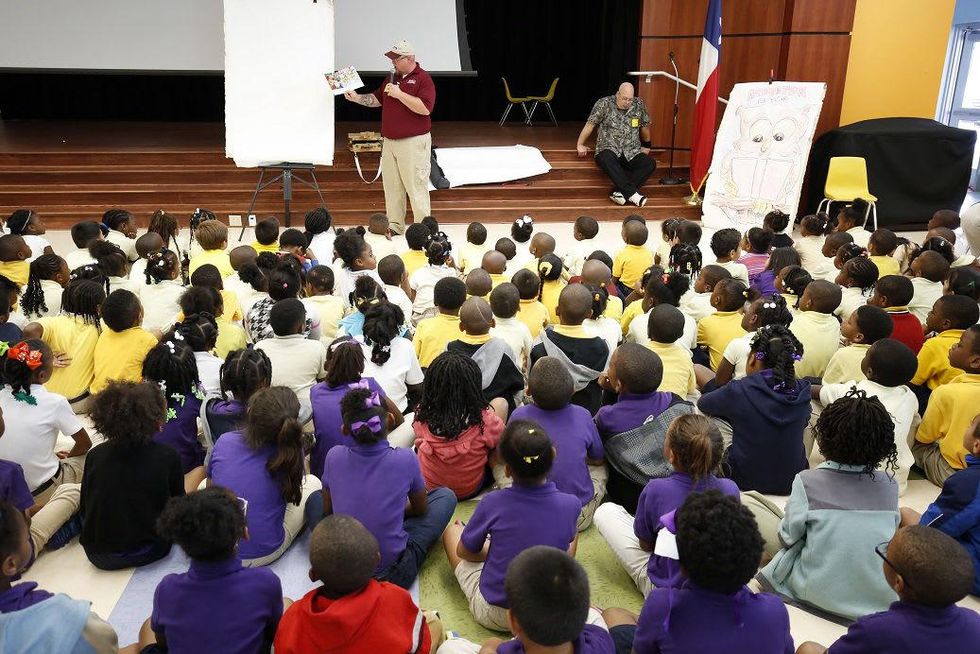 John Moore technician Patrick Middleton reads the original story "Buddy, the Home Repair Bear" to the pre-K and kindergarten students at Atherton Elementary School