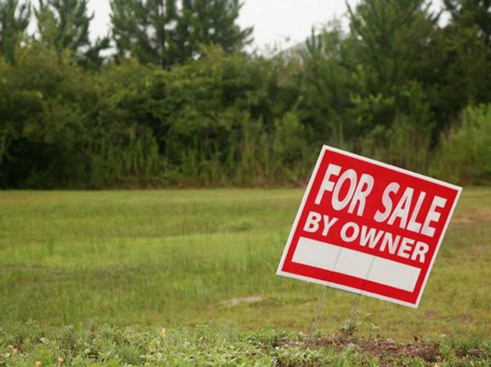 Land for sale by owner sign in empty lot property for sale