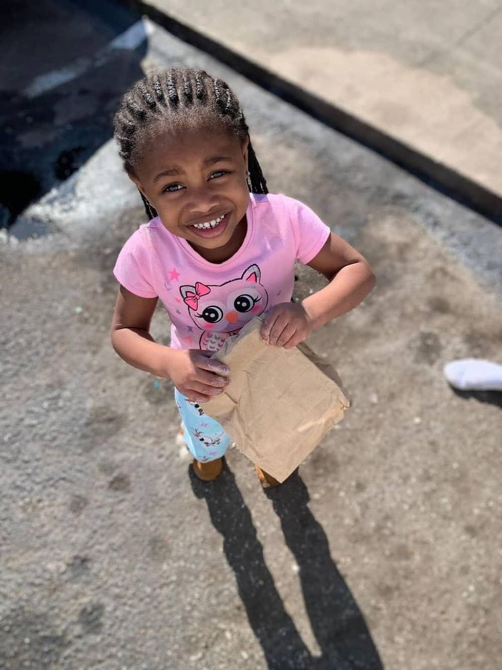 Little girl holding sack lunch