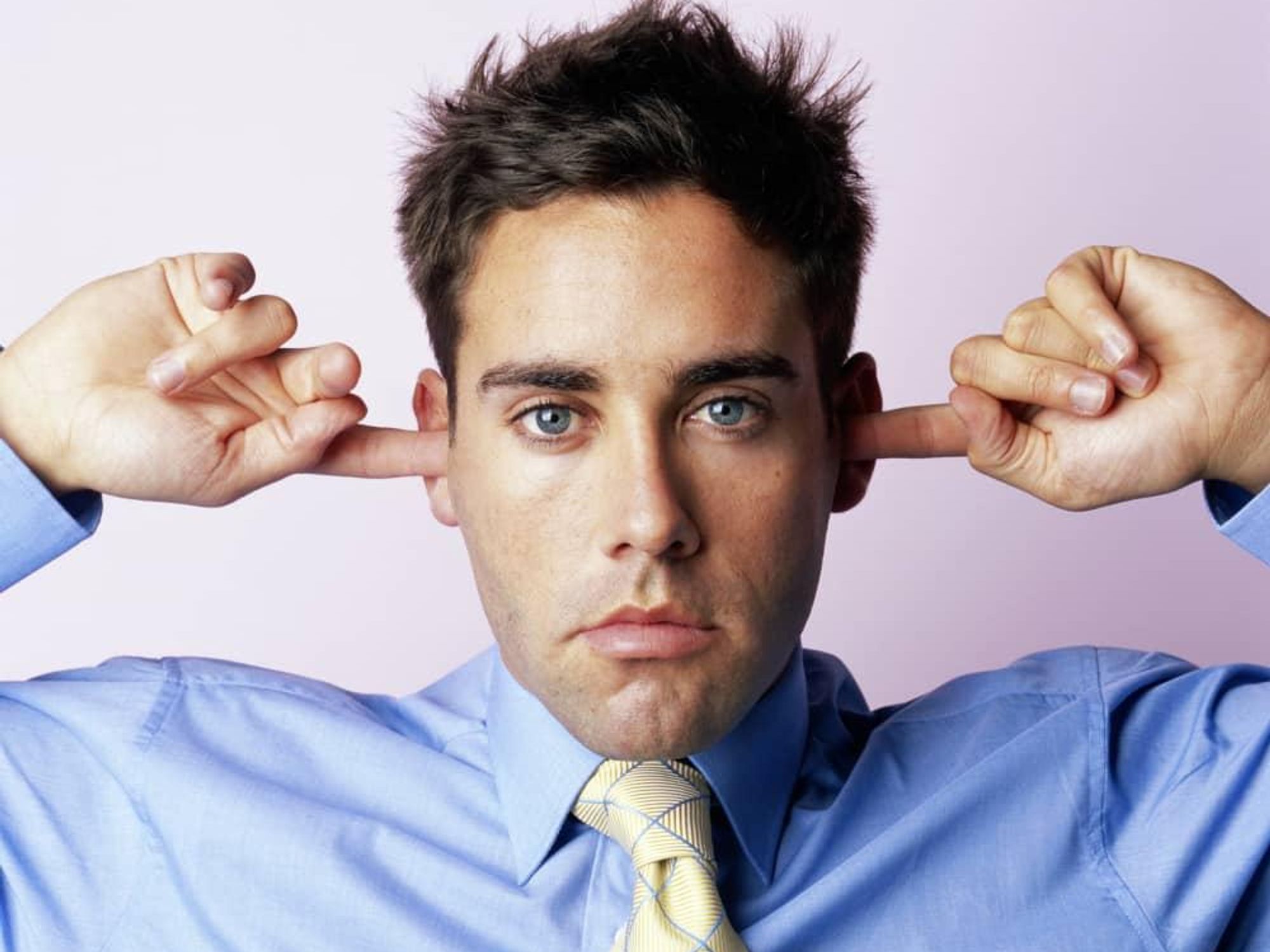 loud noise man with fingers in ears