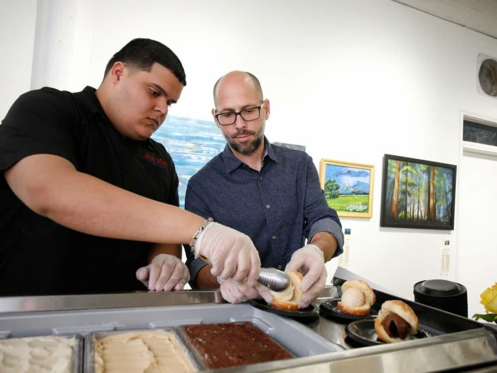 Luis Santana and Jason Richburg of Lee\u2019s Creamery prepare doughnut ice cream sandwiches for Preview Party guests at Art on the Avenue.