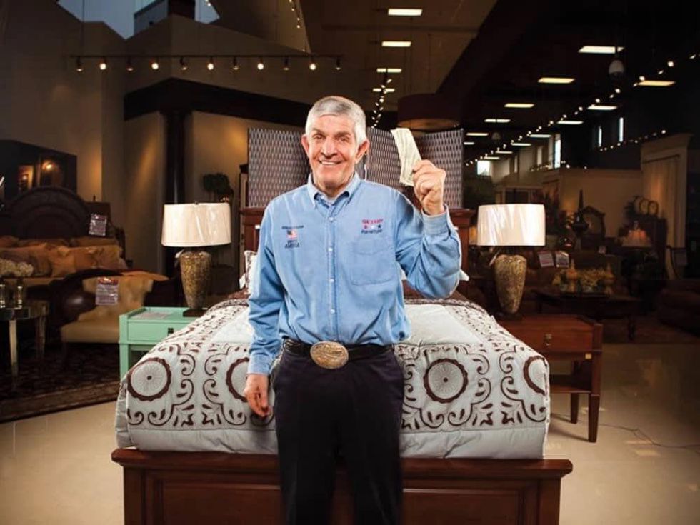 Mattress Mac or Jim McIngvale of Gallery Furniture holding up dollar bills