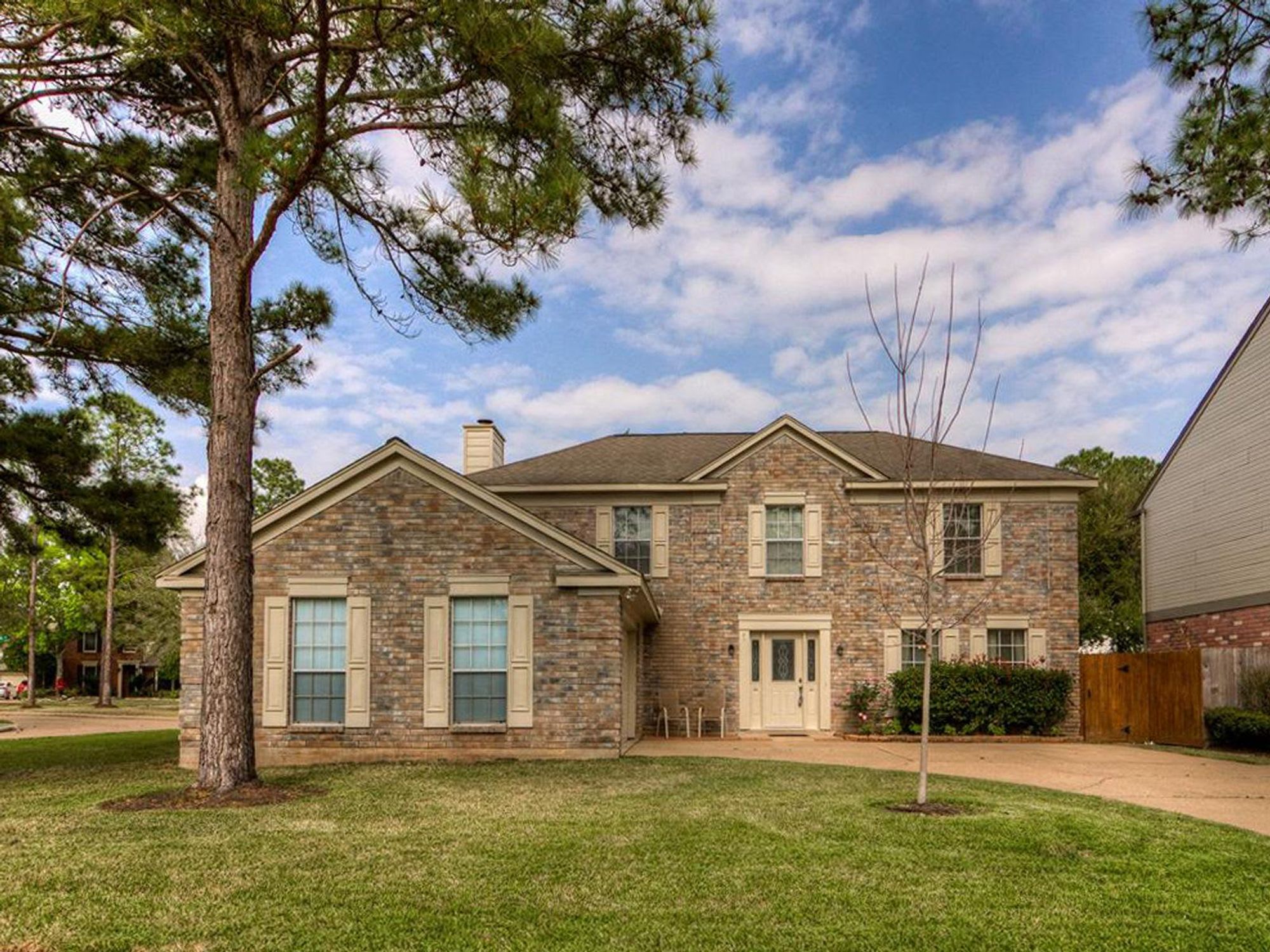 median home in Houston house front with pine trees and lawn